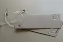 Grey board hang tags with blind embossing and clear string