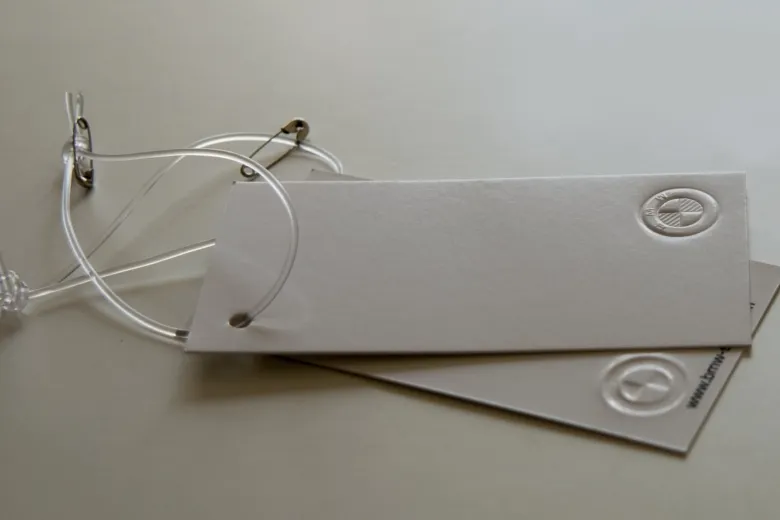 Grey board hang tags with blind embossing and clear string