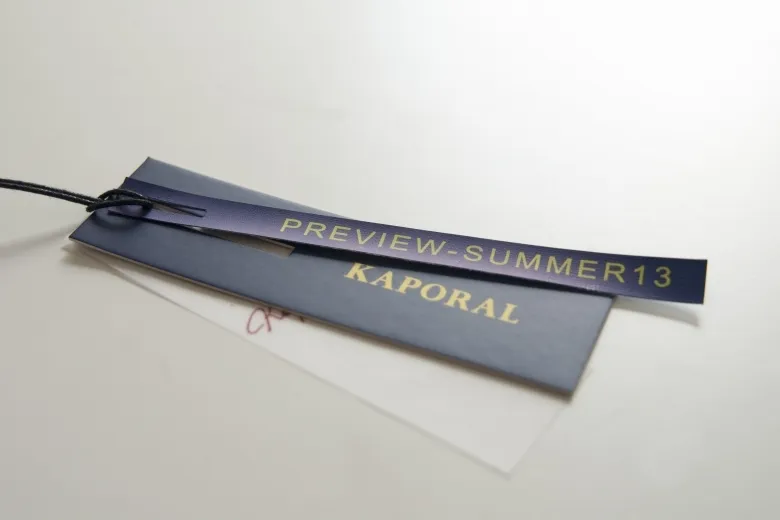 Layered hang tags with gold foil text and black string